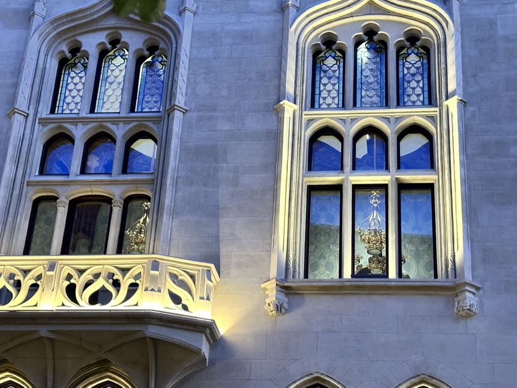 Architectural lighting on the stone windows and balcony of a heritage building